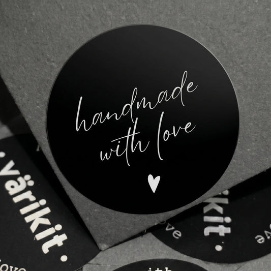 Black circular sticker with 'handmade with love' text on a gray background