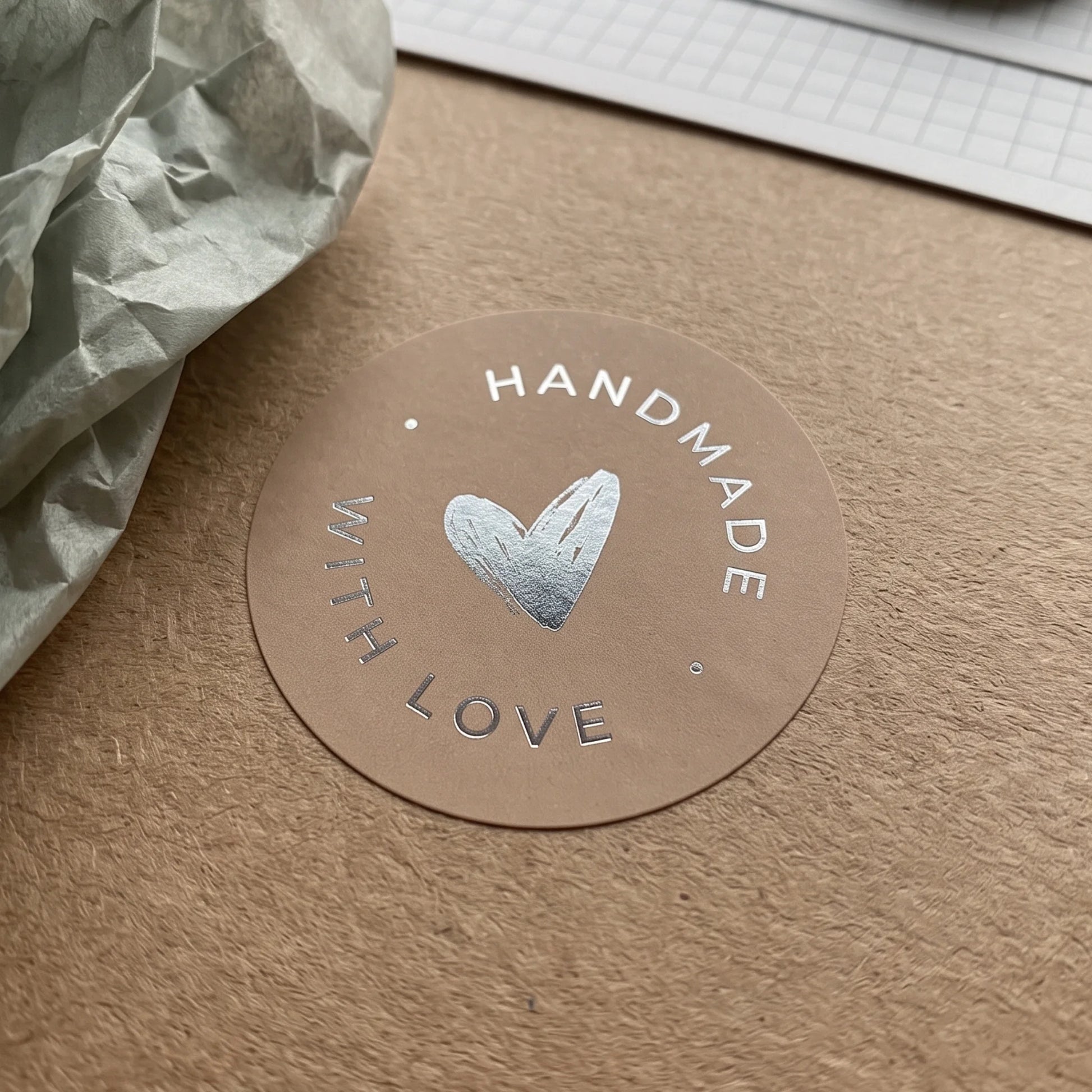 A hand-lettered scribbled heart label adding a maker detail to product bags.