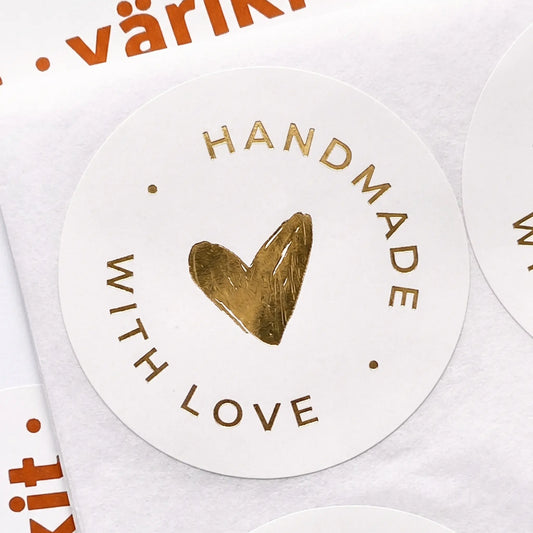 Round gold foil label with 'Handmade with Love' text and a heart symbol on a white background.