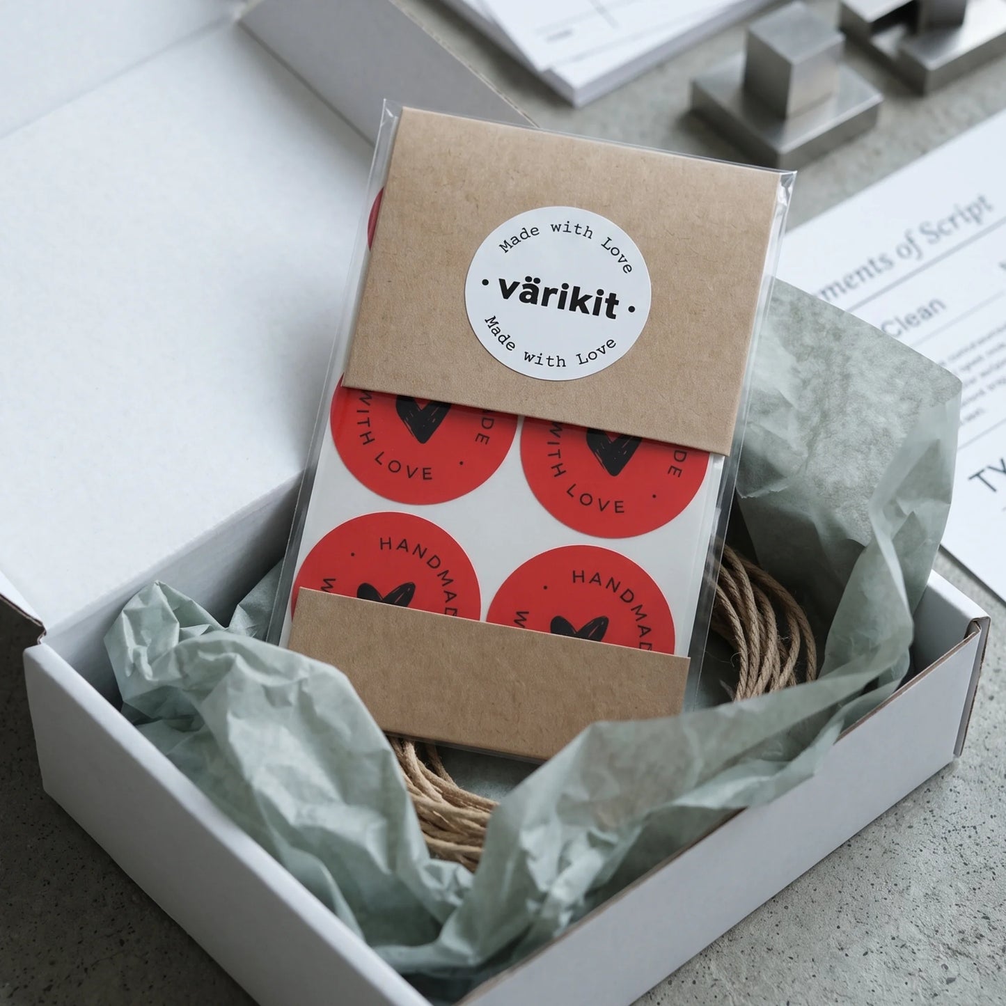 A hand-lettered scribbled heart sticker arriving on boutique gift boxes.