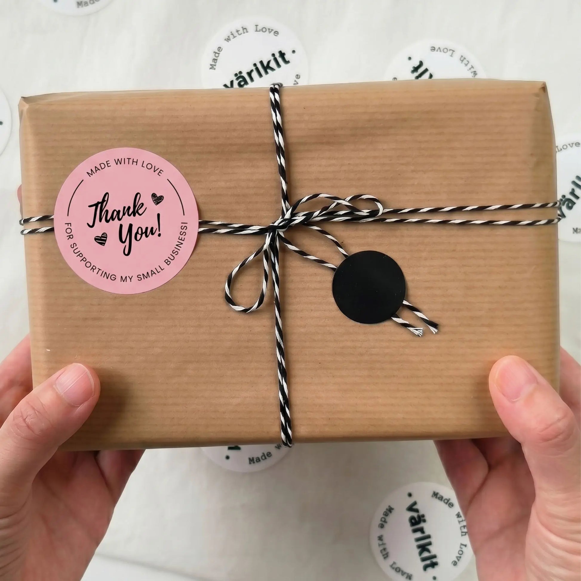 Brown paper-wrapped gift with a pink 'Thank You!' sticker held by hands on a white background with 'varikit' branding.