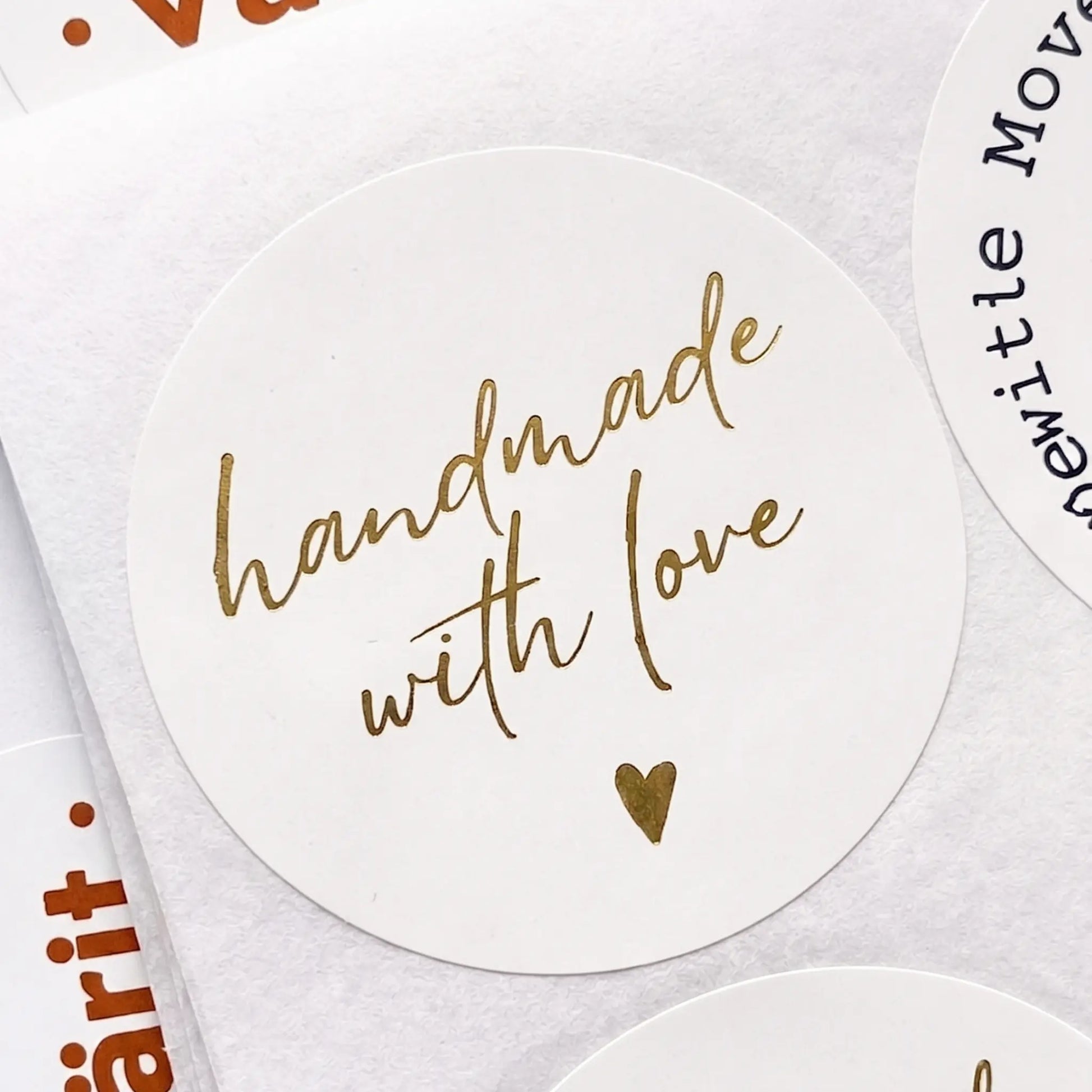 Round gold foil sticker with 'handmade with love' text on a white background