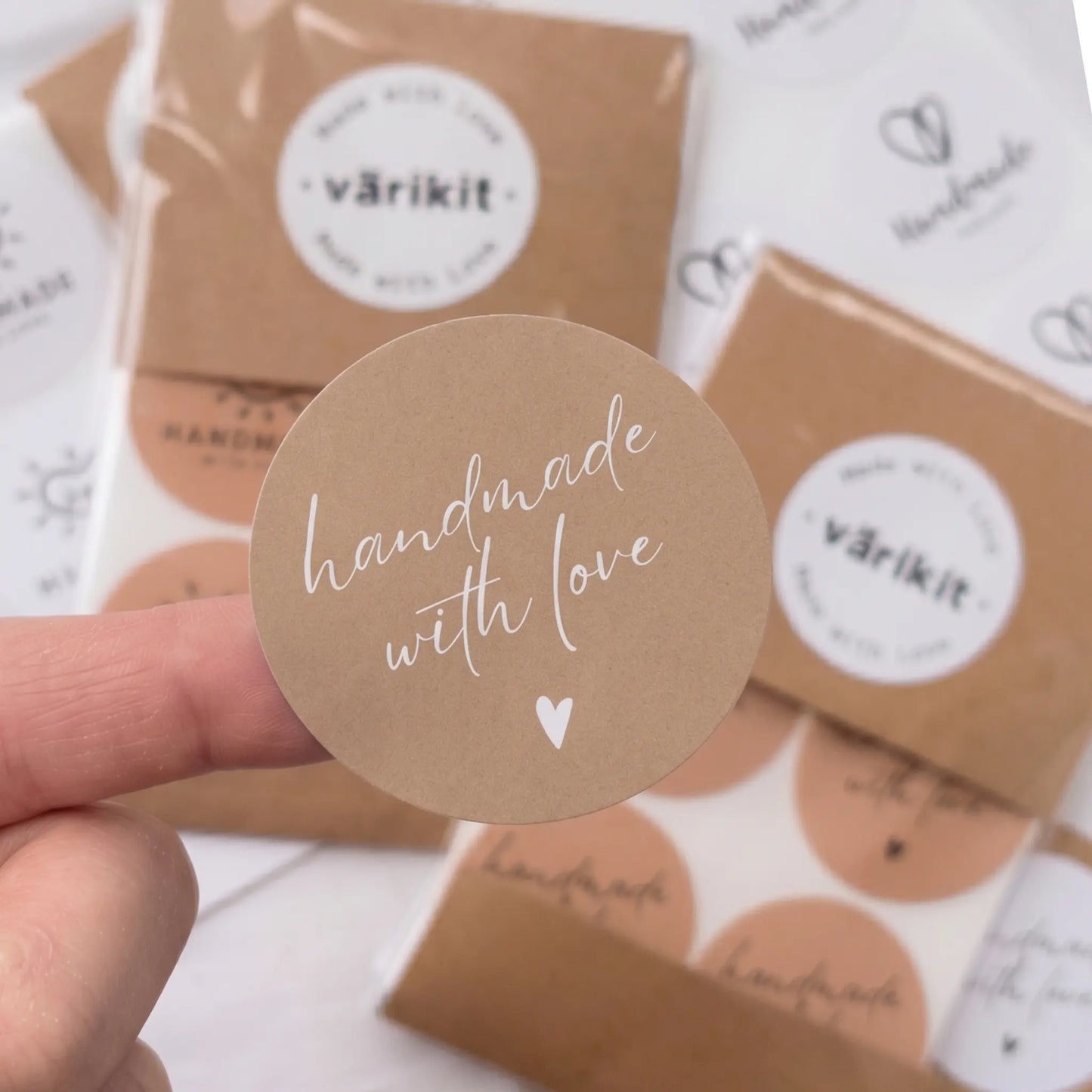Round brown sticker with 'handmade with love' text held by a hand, with 'varikit' packaging in the background.