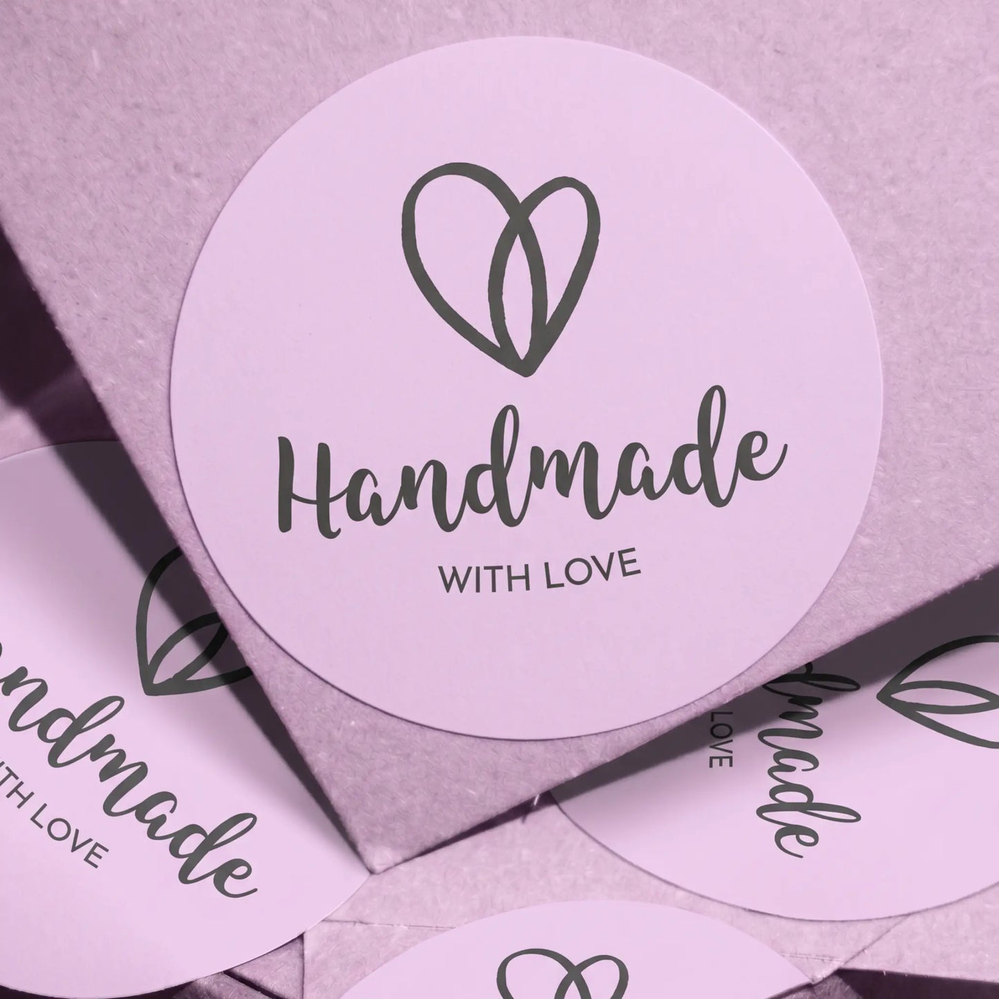 Heart-shaped stickers with 'Handmade with Love' text on a light purple background