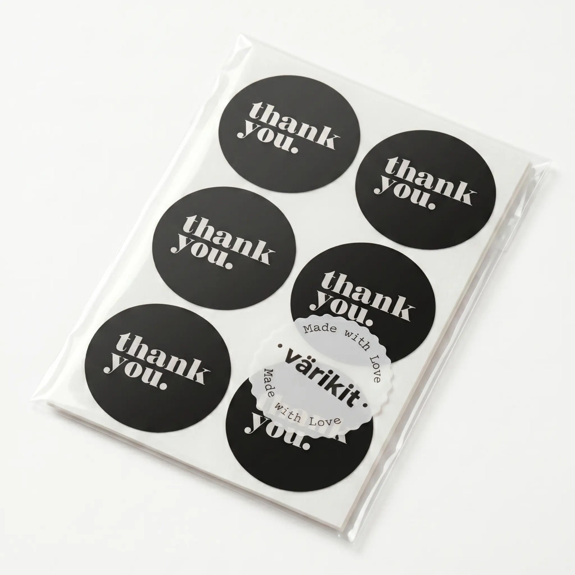 Pack of black 'thank you' stickers with a clear plastic sleeve on a white background