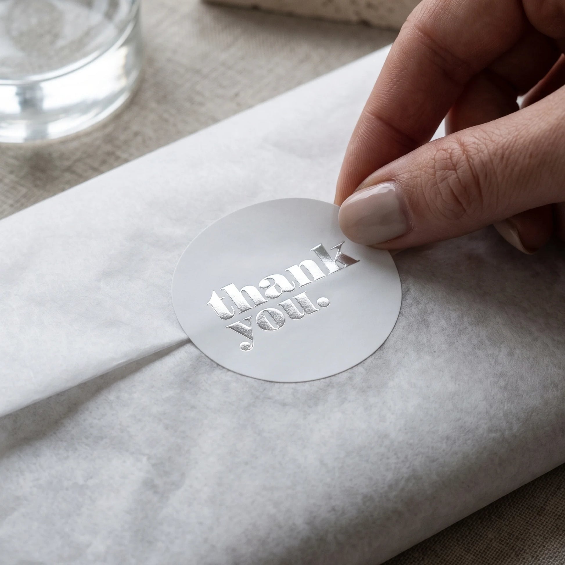 A bold thank you sticker greeting small business customers as they open gift wraps.