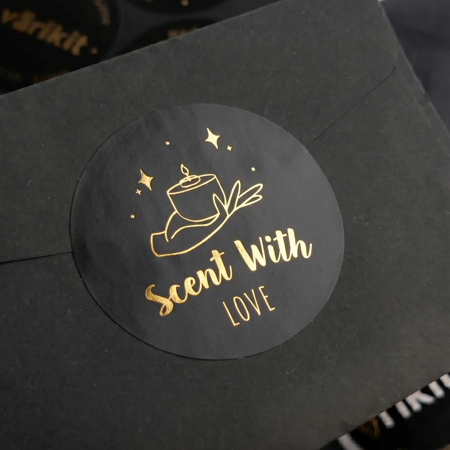 Black product packaging with a gold 'Scent With Love' label on a black background