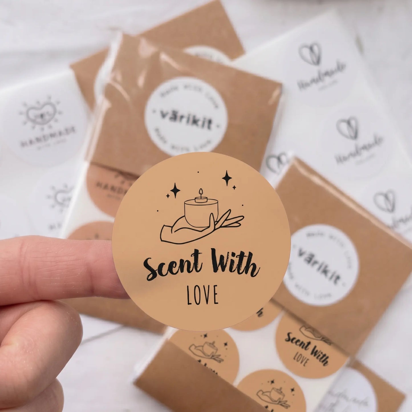 Round brown label with 'Scent With Love' text held over packages with 'varikit' branding.