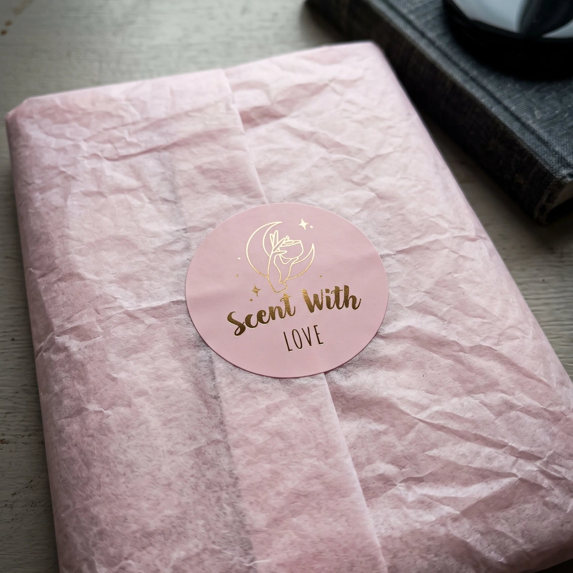 Scent With Love Mystic Candle Hand Varikit sticker reading 'Scent with Love' sealing folded beige tissue paper wrapping.