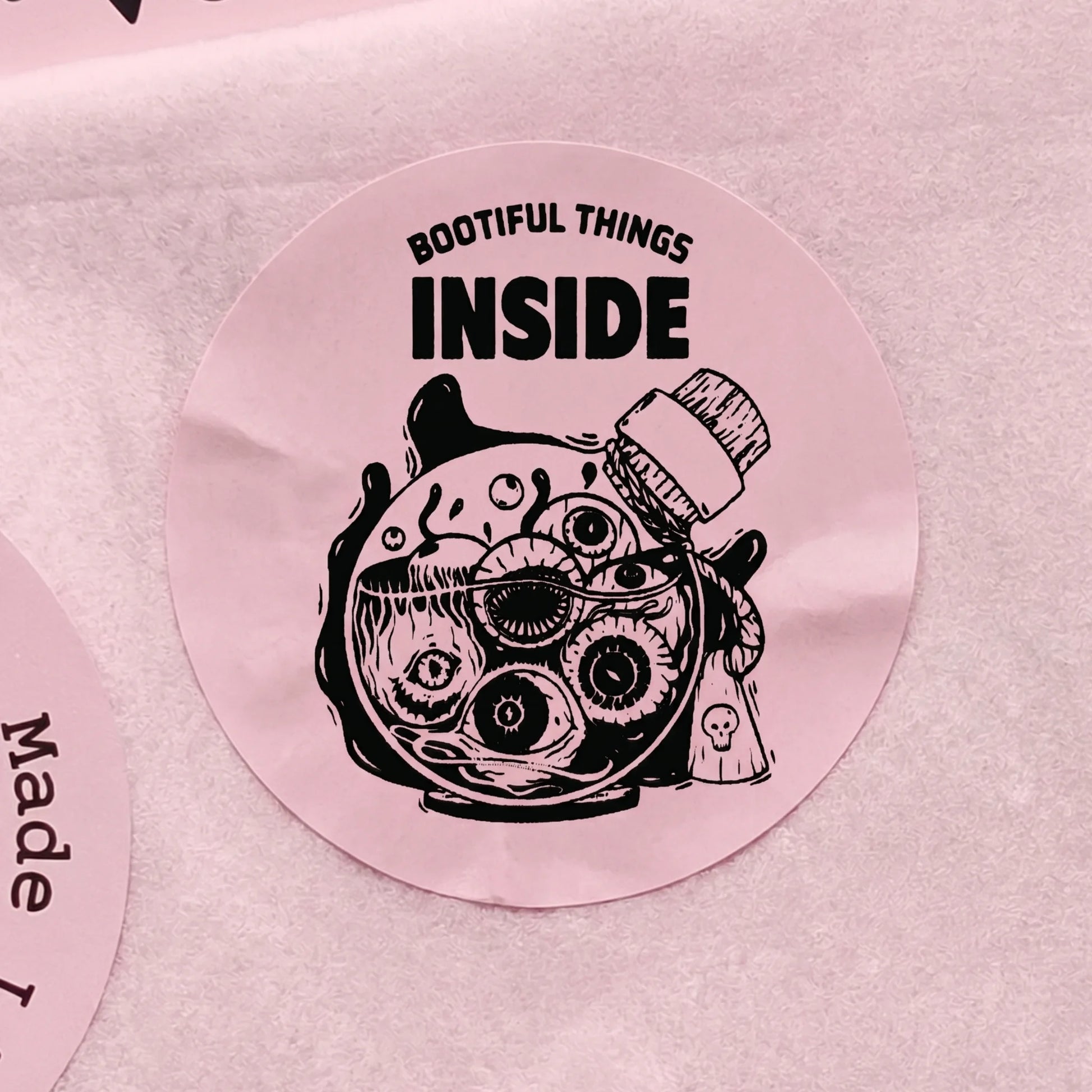 Close-up of a Playful Packaging Creepy Eyeball Jar Varikit sticker reading 'BOOTIFUL THINGS INSIDE'.