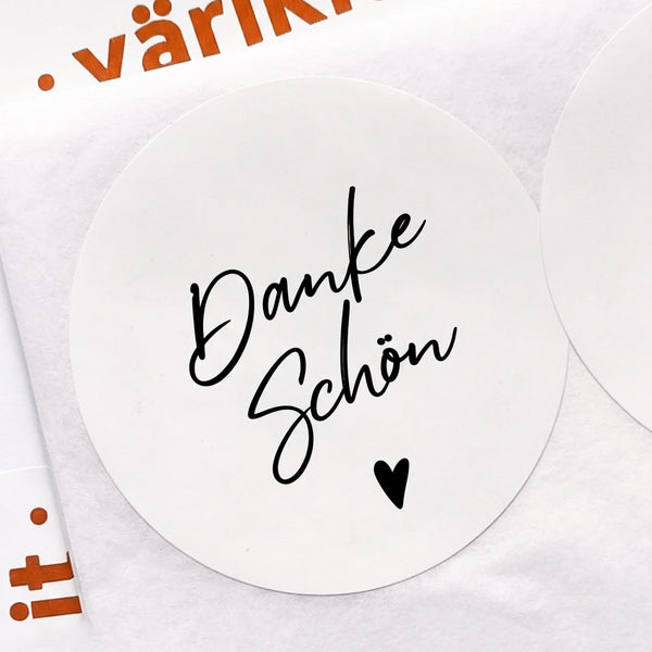 Round white sticker with 'Danke Schön' text and a heart on a white background