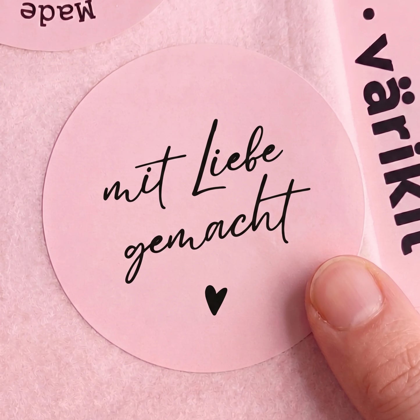 Pink sticker with 'mit Liebe gemacht' text on a pink background