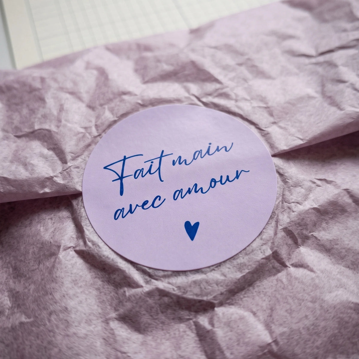A flowing French cursive typography sticker identifying signature parcels.