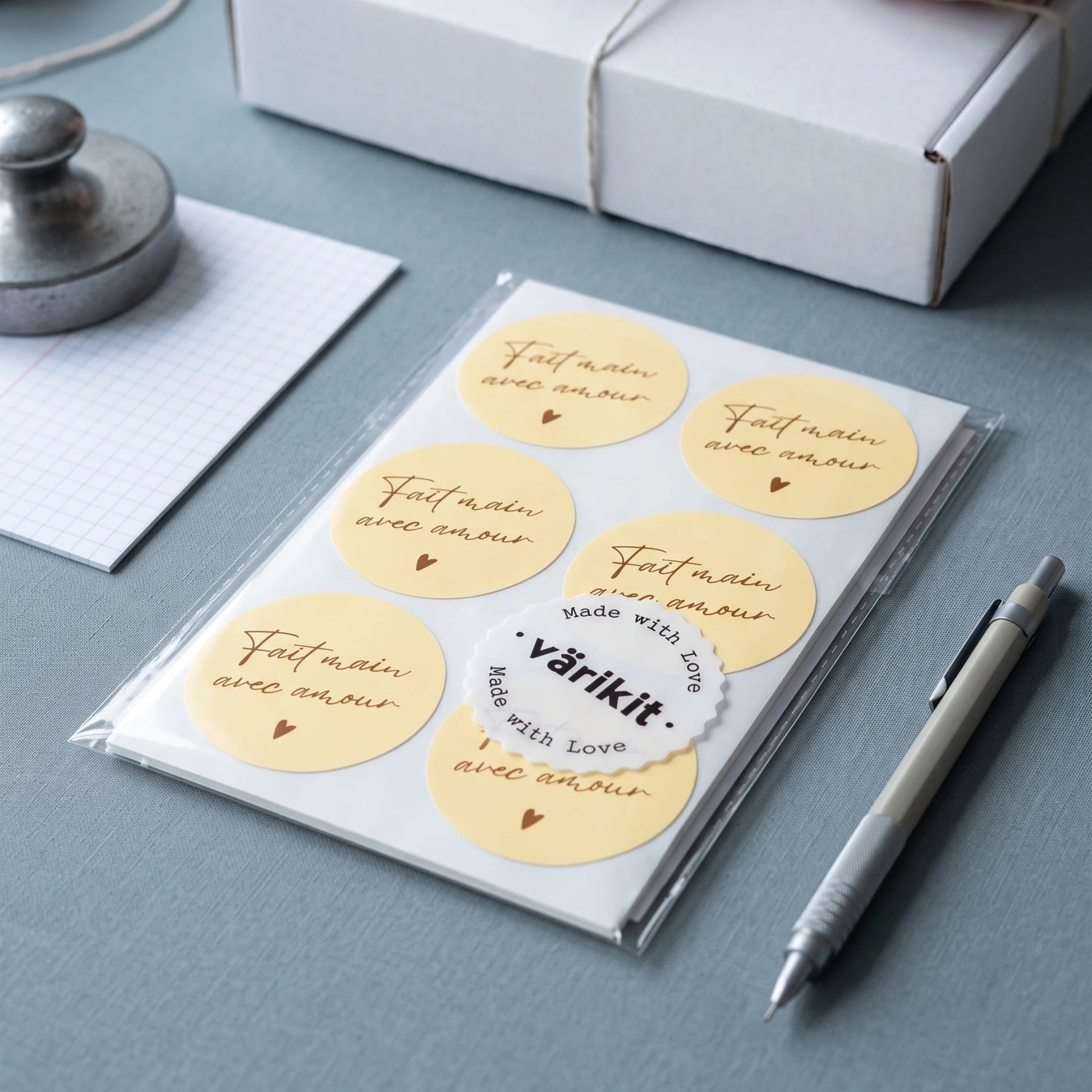 Seal artisan product boxes with a handwritten French handmade paper label.